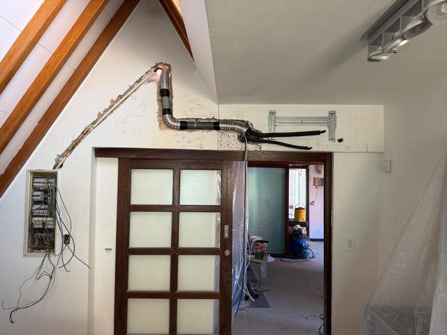 Attic wall opened up for new conduit and refrigerant lines